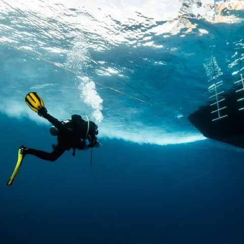 Diver cleaning boat hull